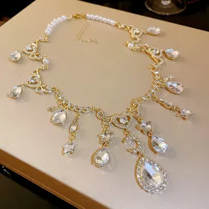 Detail view of a vintage gold-toned necklace with rhinestones, pearls, moon and star motifs.