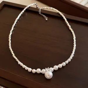 Gros plan d'un collier français rétro en perles et zircons sur un plateau en bois foncé
