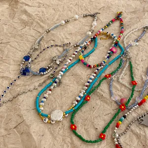 Collares de cuentas coloridos hechos a mano con dijes Y2K sobre fondo de papel arrugado