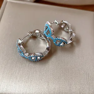 Detail of vintage silver hoop earrings with turquoise stones and pig nose design