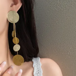 Elegant close-up shot of golden textured multi-disc long tassel earrings worn by a model