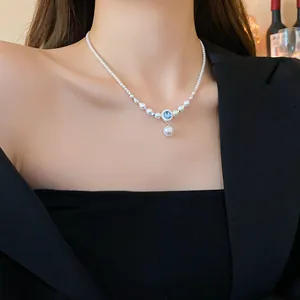 Collier de perles vintage français élégant avec pendentif en zircon bleu sur modèle.
