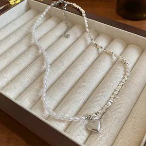 Gros plan d'un élégant collier de perles avec pendentif coeur dans un bel écrin.