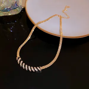 Detail view of luxury gold-plated curved necklace featuring black enamel and rhinestones.