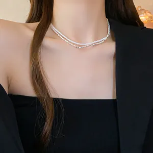 Gros plan d'un collier ras du cou à double rangée de perles et de zircons sur un modèle.
