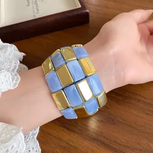 Elegante bracciale patchwork in acrilico con tasselli blu cielo e oro in stile moderno