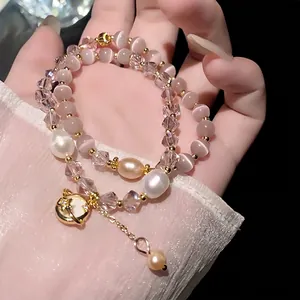 Elegante bracciale a doppio strato con pietre occhio di gatto rosa, cristalli e perle.