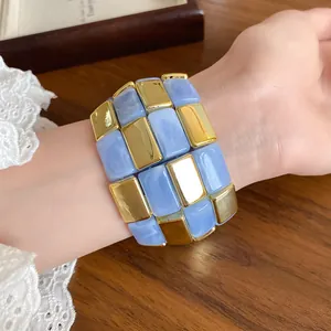 Dettaglio ravvicinato di un bracciale patchwork in acrilico marmo blu e oro per donna