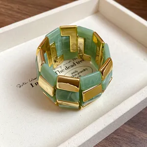 Primo piano di un bracciale chunky con maglie in acrilico verde e metallo dorato
