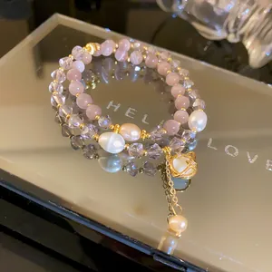 Dettaglio macro di un elegante bracciale a doppio strato in pietra occhio di gatto e perle