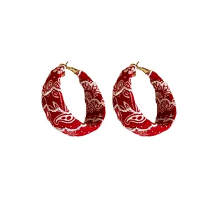 Red fabric wrapped hoop earrings featuring elegant white paisley floral designs