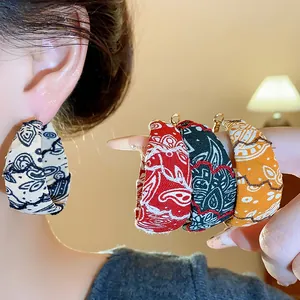Close-up showing fabric printed hoop earrings in multiple colors with silver needles