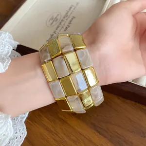 Dettaglio delle tessere quadrate in acrilico marmorizzato e oro lucido del bracciale