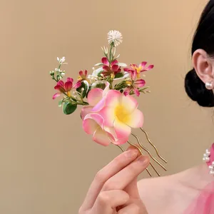 Detailed close-up of a sweet fabric flower hair fork with pink and yellow floral accents