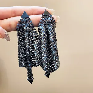 Detailed close-up of chic black sequined mesh drop earrings with triangle studs