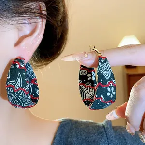 Macro view of ethnic style fabric hoop earrings featuring intricate floral print details