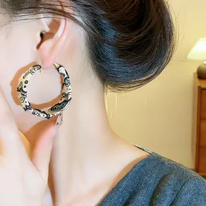 Detailed close-up of fabric wrapped hoop earring with black paisley print pattern