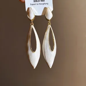 Elegant white drip oil hollow waterdrop earrings with vintage gold finish and minimalist design