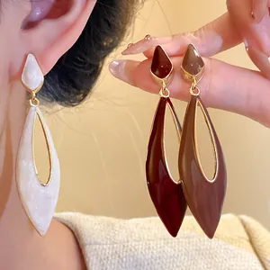 Detail shot of elegant hollow teardrop enamel drop earrings in varied retro colors