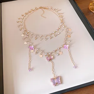 Detailansicht einer eleganten mehrlagigen Goldkette mit funkelnden lila Strass-Schmetterlingen