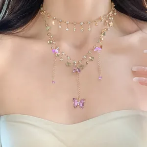 Exquisites Detail einer mehrlagigen goldenen Schmetterlingskette mit lila Kristallen und Strass