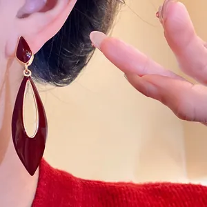 Close-up of vintage burgundy teardrop hollow drop earrings with S925 silver needles.