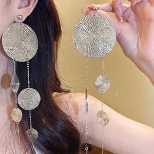 Statement silver needle earrings with circular textured metal plates and long tassels