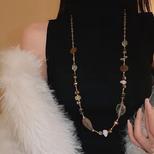 Vista dettagliata di una collana lunga etnica vintage con perline di agata su una modella.