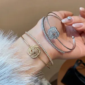Elegant double-layered open bangle with zircon-studded flower motif in gold and silver