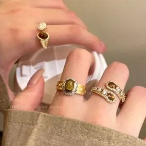 Détail de bagues plaquées or avec pierres œil de tigre et zircons étincelants