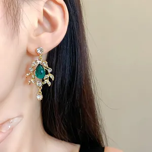 Detailed view of exquisite vintage palace style green water drop leaf earrings on ear