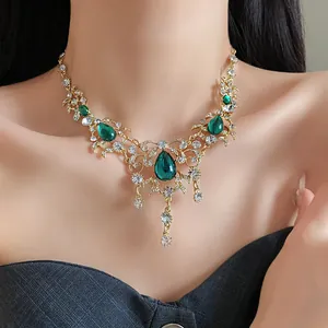 Detailed close-up of a vintage-style gold necklace with green waterdrop pendants.