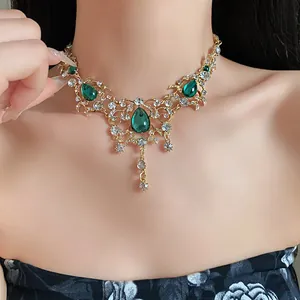 Close-up of elegant vintage court style necklace with green teardrop crystals on model
