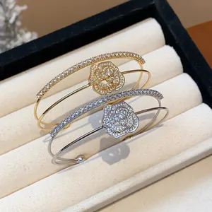 Detail shot of elegant gold and silver rose flower bangles with zircon pavé settings