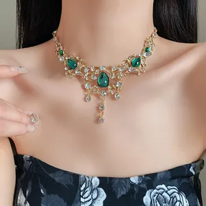 Close-up detail of vintage palace style gold necklace with elegant green water drop pendants