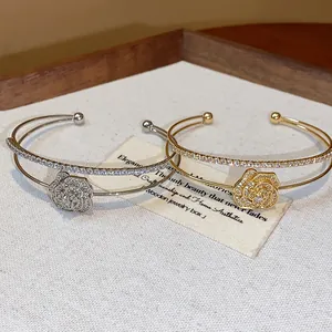 Detail view of gold and silver double-layer rose flower bracelets with sparkling stones