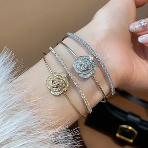 Detailed close-up of elegant rose flower bangles with sparkling zircon pavé on woman's wrist