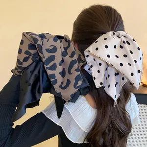 Rear view of elegant leopard and polka dot bow hair claw clips on wavy brown hair