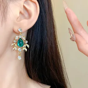 Detail shot of vintage court style earring with green water drop gem and rhinestones