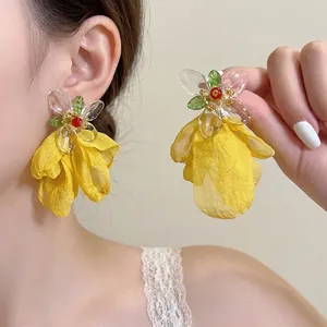 Close-up detail of elegant yellow chiffon flower tassel earrings with clear acrylic petals