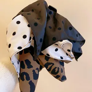 Detailed view showing the fabric texture of a polka dot and leopard print hair claw clip.