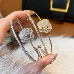 Detailed view of exquisite double-layer zircon flower bangles in gold and silver finishes.