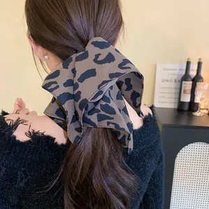 Elegant leopard print hair scarf bow tied on a low ponytail for women's hairstyle