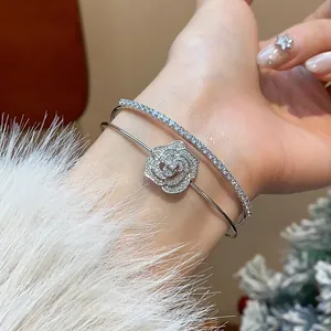 Macro view of silver double-layer open bracelet featuring an elegant zircon camellia flower.