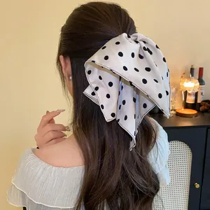 Elegant white polka dot bow hair claw clip for a sophisticated back-of-head hairstyle.