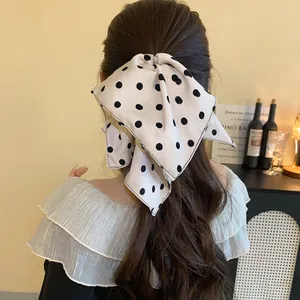Close-up detail of an elegant white polka dot bow hair clip styled on the back of head