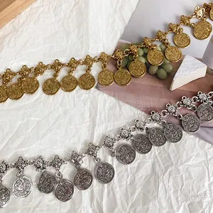 Detailed view of ethnic style coin tassel waist chain belts in gold and silver finishes
