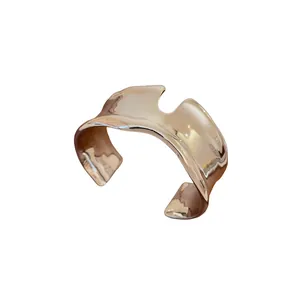 Modern liquid-style irregular open cuff bracelet in polished rose gold finish.