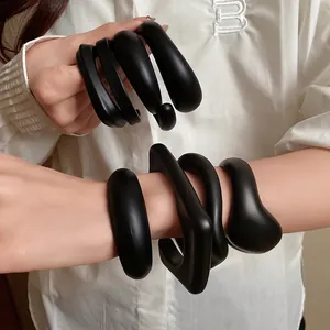 Minimalist black acrylic open bangles with unique geometric shapes for a modern look.