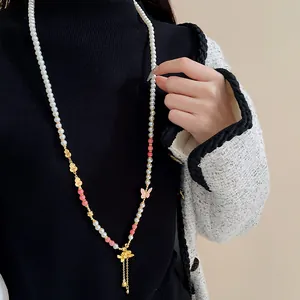Vista dettagliata di collana di perle neo-cinese con ciondoli a loto e farfalla.